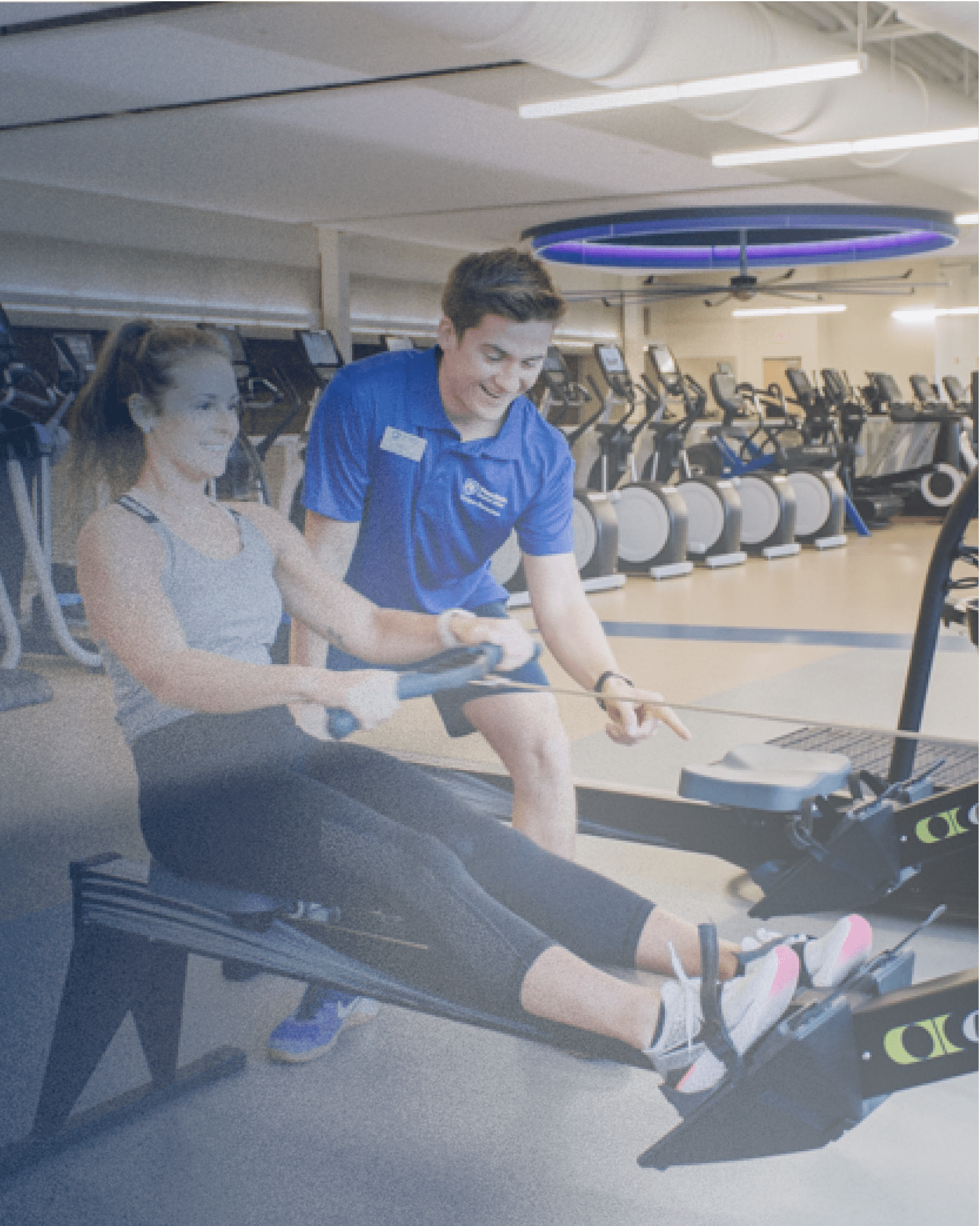 Personal trainer helping a client at a campus gym